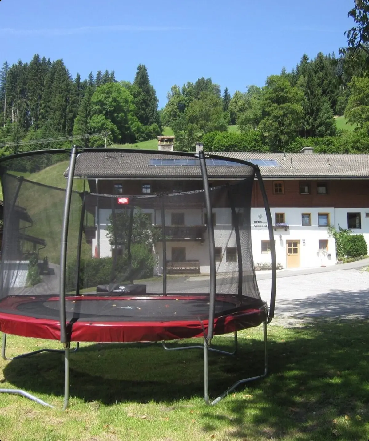 Trampolin in der Wiese vor dem Haus, außerdem: Sandkasten, Boulderwand und Lagerfeuerstelle | © DAV Regensburg