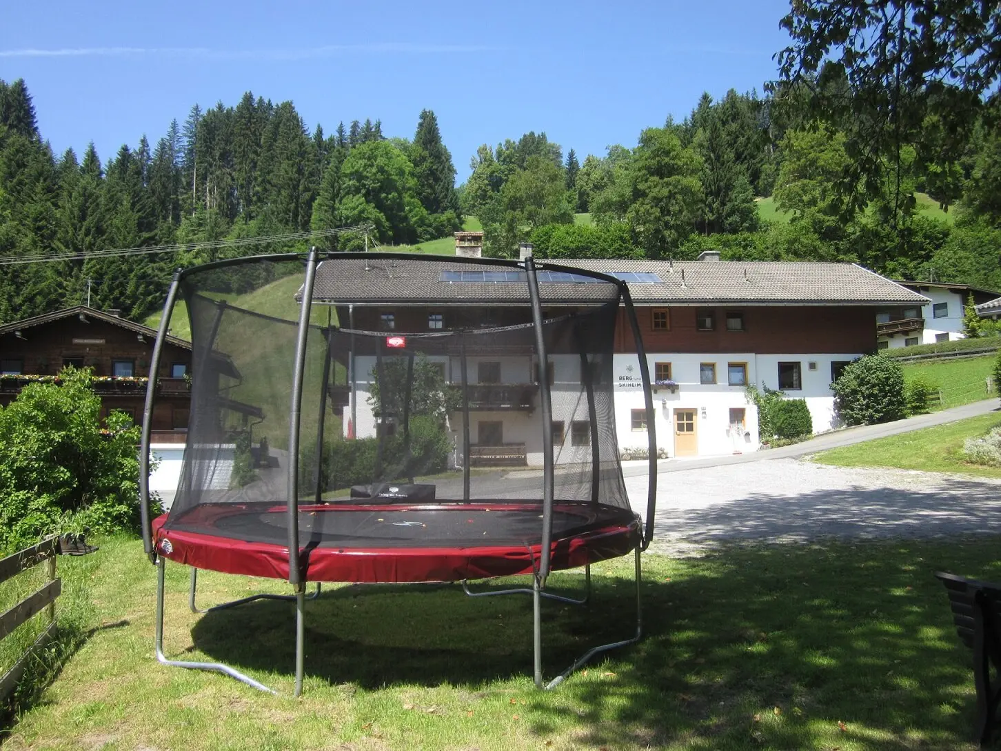 Trampolin in der Wiese vor dem Haus, außerdem: Sandkasten, Boulderwand und Lagerfeuerstelle | © DAV Regensburg