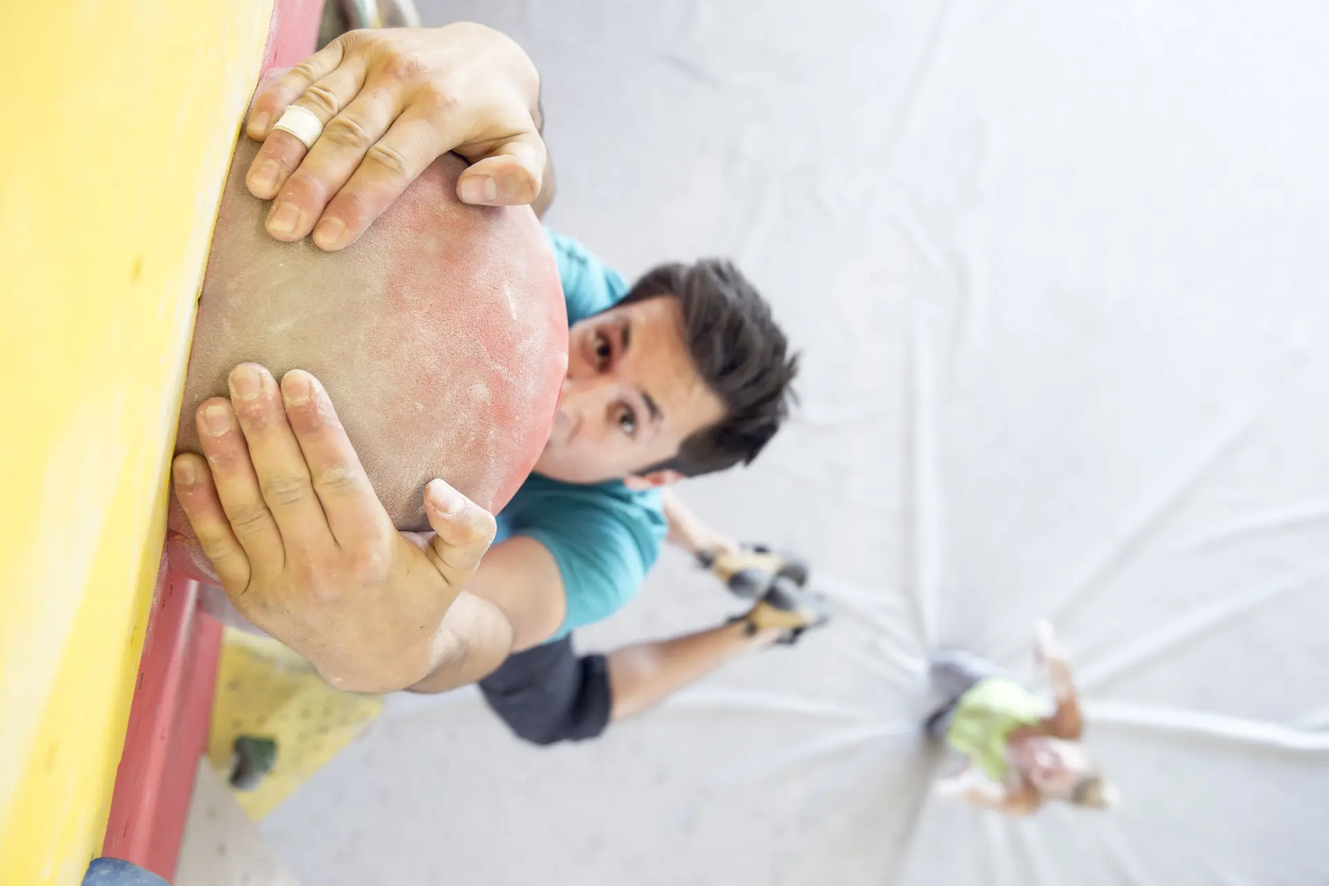 Ein Mann beim Bouldern aus der Vogelperspektive fotografiert, seine Partnerin spottet im Hintergrund. | © DAV/ Hansi Heckmair