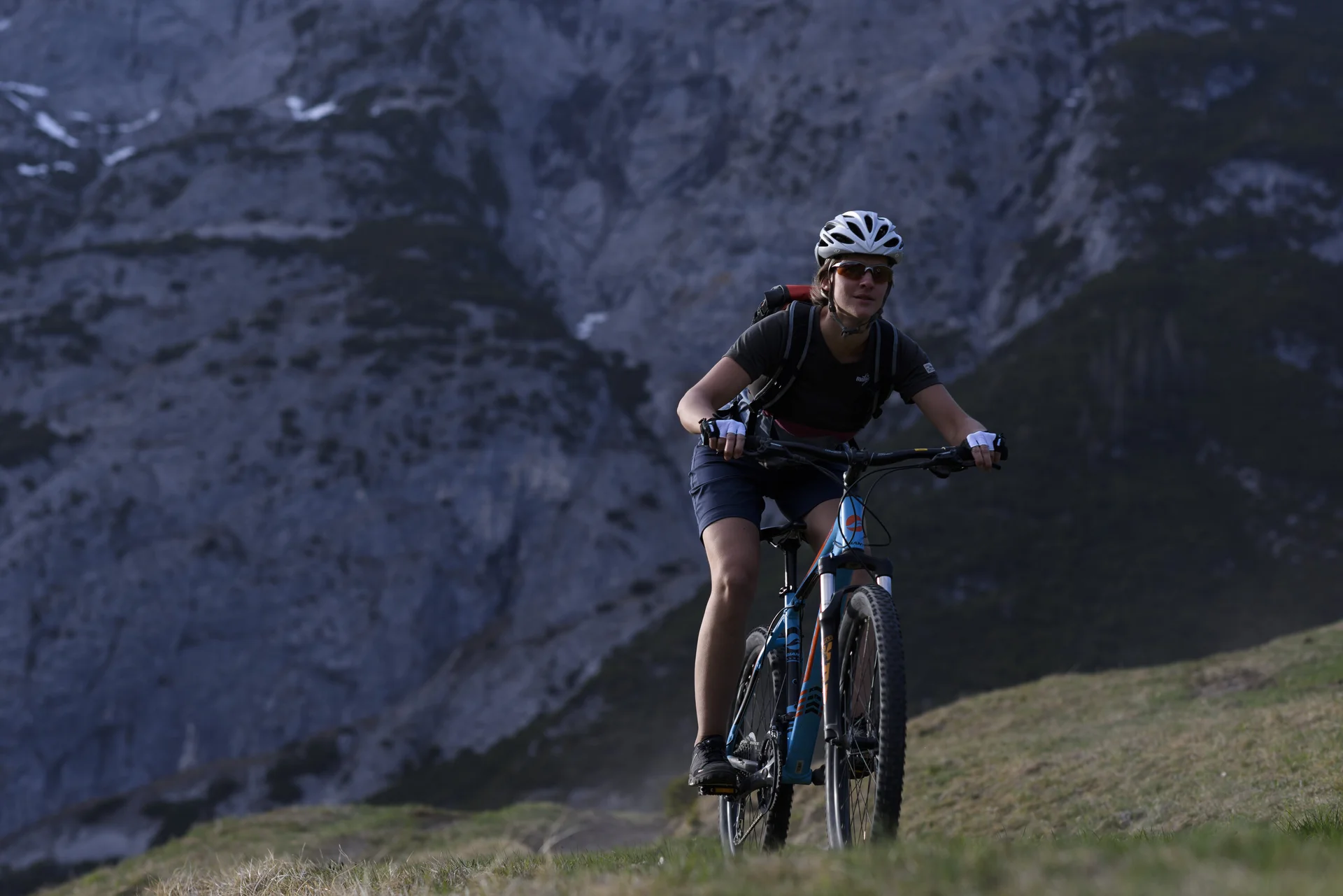 Eine Mountainbikerin fährt einen Trail in den Bergen hoch. | © DAV/Wolfgang Ehn